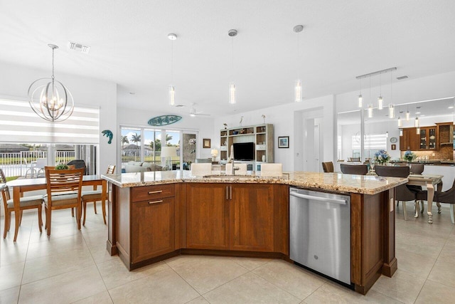 kitchen with stainless steel dishwasher, ceiling fan with notable chandelier, pendant lighting, and an island with sink