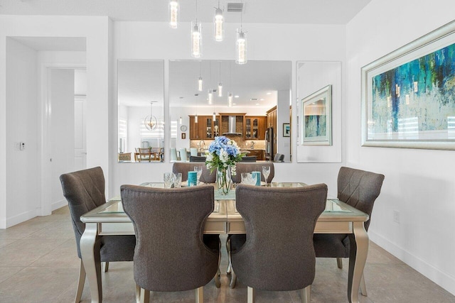 dining area with tile patterned floors and a notable chandelier