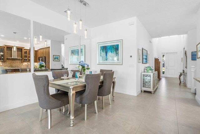 dining room with a towering ceiling and light tile patterned flooring