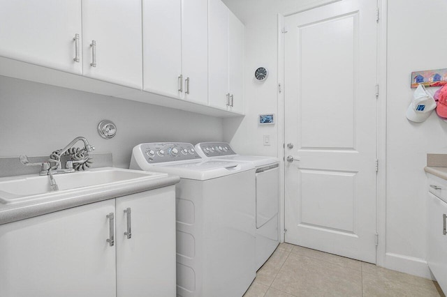 washroom with cabinets, light tile patterned floors, independent washer and dryer, and sink