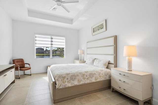 bedroom with ceiling fan and a raised ceiling