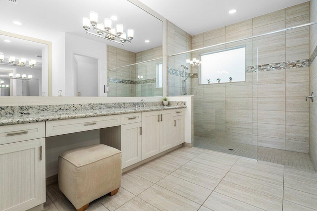 bathroom featuring tile patterned flooring, vanity, and tiled shower