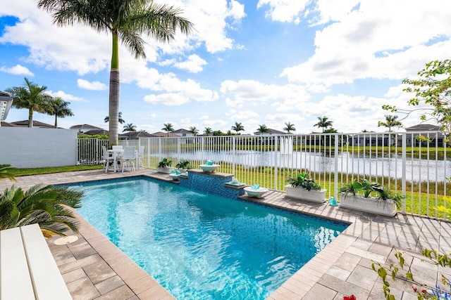 view of swimming pool with a patio area and a water view