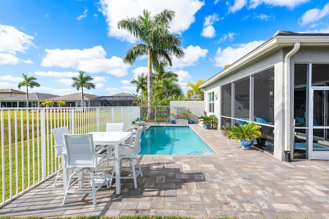 view of pool featuring a sunroom, a patio, and a lawn