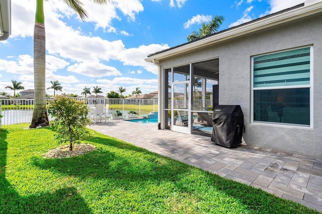 exterior space featuring a fenced in pool, area for grilling, and a sunroom