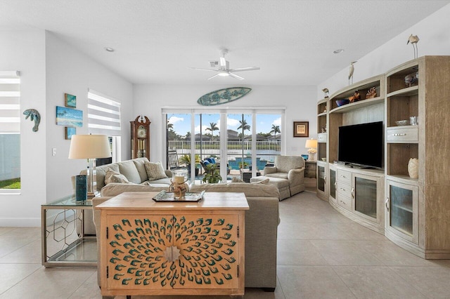 living room featuring light tile patterned floors, a textured ceiling, and ceiling fan