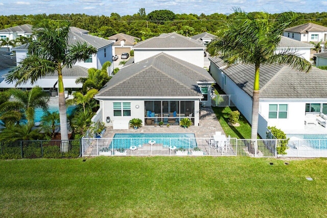 rear view of house featuring a fenced in pool, a yard, and a patio