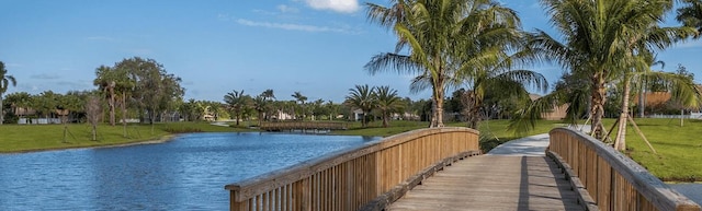 view of property's community with a lawn and a water view