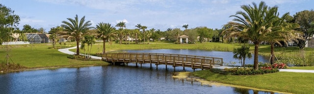 view of home's community featuring a lawn and a water view