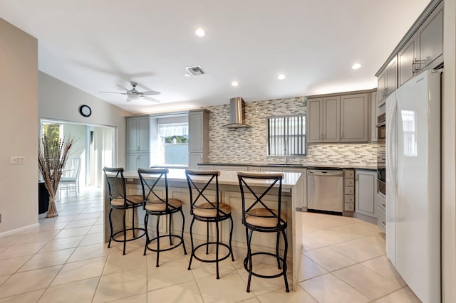 6761 Sun River Rd, Boynton Beach, FL 33437 - kitchen with appliances with stainless steel finishes, gray cabinetry, wall chimney range hood, backsplash, and recessed lighting