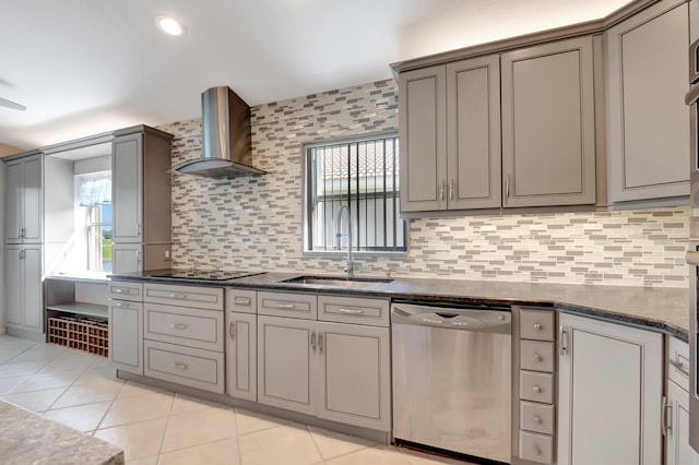 kitchen with sink, wall chimney range hood, stainless steel dishwasher, backsplash, and dark stone counters