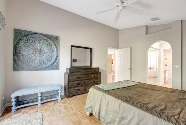 bedroom featuring light parquet flooring, ensuite bath, and ceiling fan