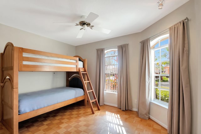 bedroom featuring ceiling fan, light parquet floors, and multiple windows