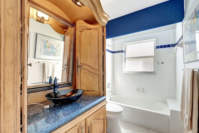 full bathroom with tile patterned flooring, vanity, tiled shower / bath combo, and toilet