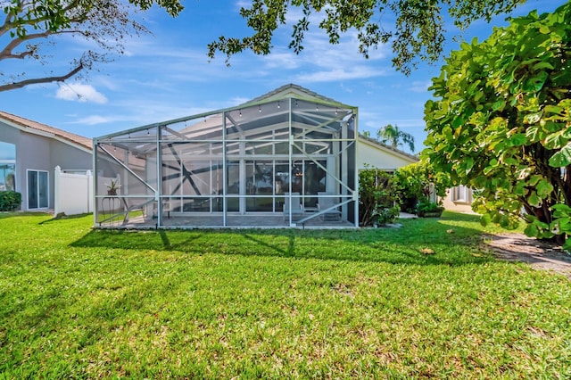 back of property with a lanai and a yard