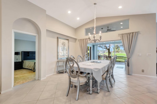 tiled dining space with lofted ceiling and an inviting chandelier