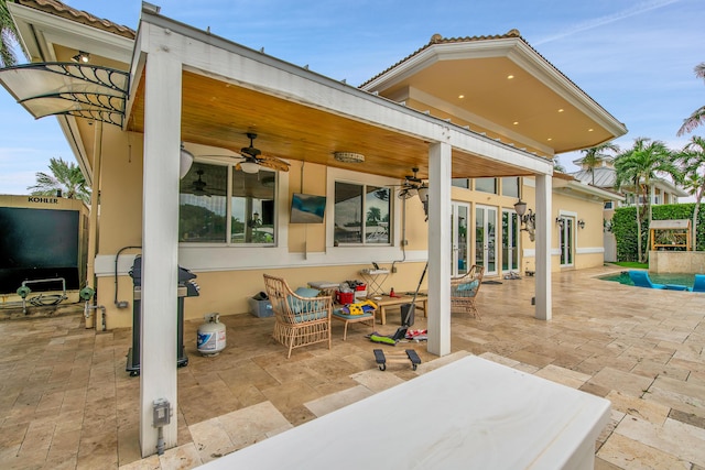 view of patio with ceiling fan, a pool, and french doors