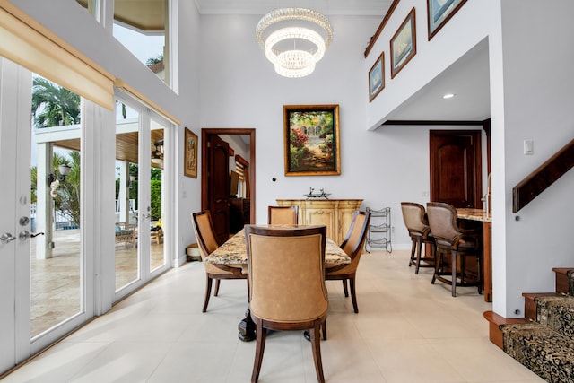 dining room with ornamental molding, a high ceiling, and an inviting chandelier