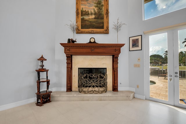 tiled living room with a premium fireplace and french doors