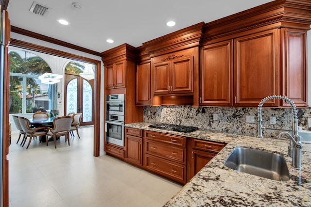 kitchen featuring black gas cooktop, crown molding, sink, tasteful backsplash, and light stone counters