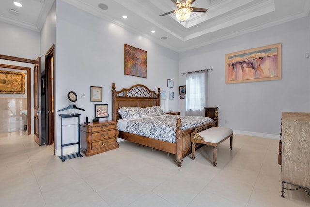 bedroom featuring a tray ceiling, ensuite bath, ceiling fan, and crown molding