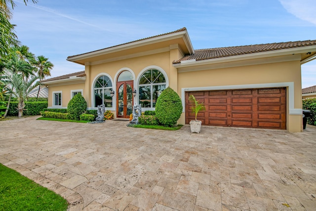 mediterranean / spanish home with a garage and french doors