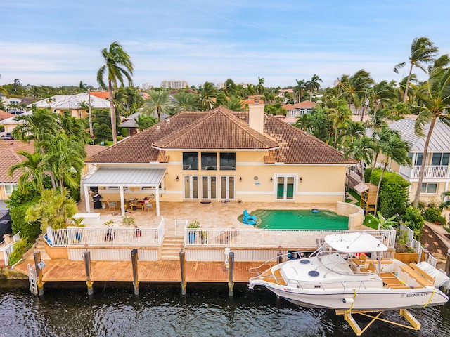 rear view of property featuring a patio area, french doors, and a water view