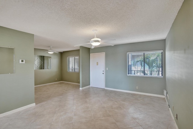 tiled spare room with ceiling fan and a textured ceiling