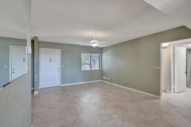 empty room with ceiling fan and a textured ceiling