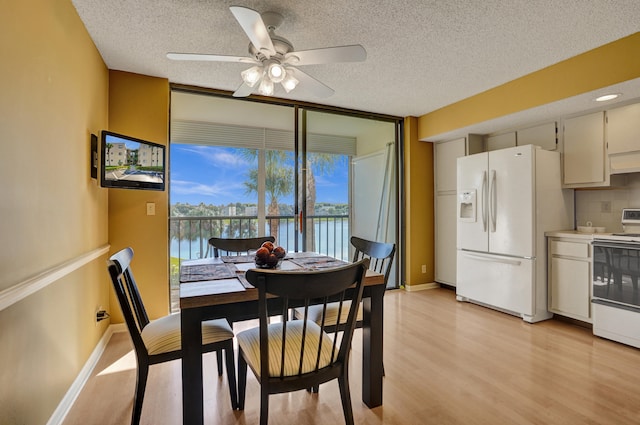 dining space with a textured ceiling, light hardwood / wood-style flooring, and ceiling fan