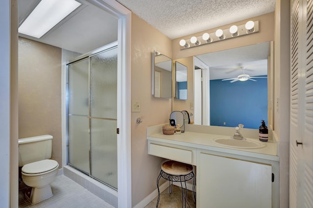 bathroom featuring vanity, toilet, a shower with shower door, and a textured ceiling