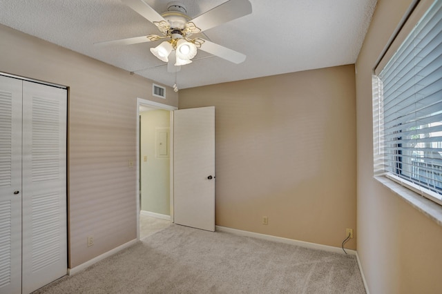 unfurnished bedroom with ceiling fan, light colored carpet, and a closet