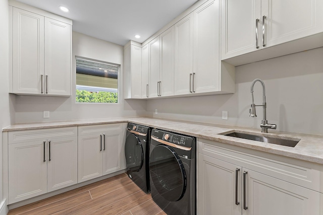 washroom featuring cabinets, washing machine and clothes dryer, and sink