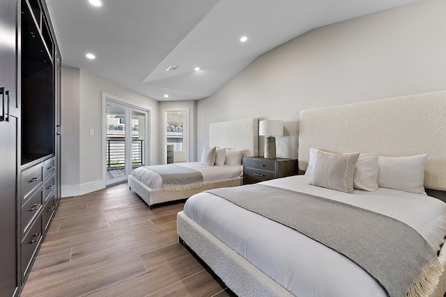 bedroom featuring vaulted ceiling, hardwood / wood-style flooring, and access to outside