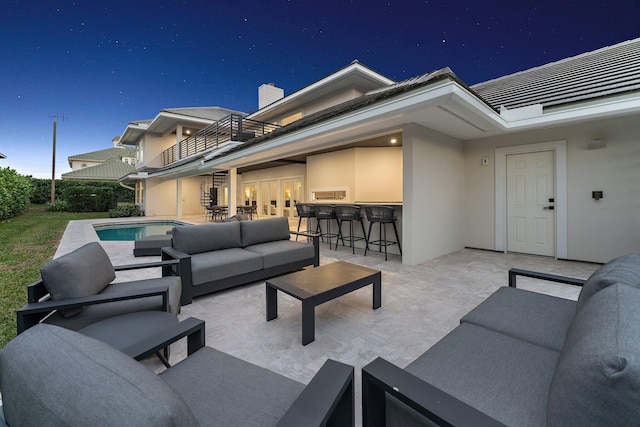 view of patio / terrace with a bar, outdoor lounge area, and a balcony