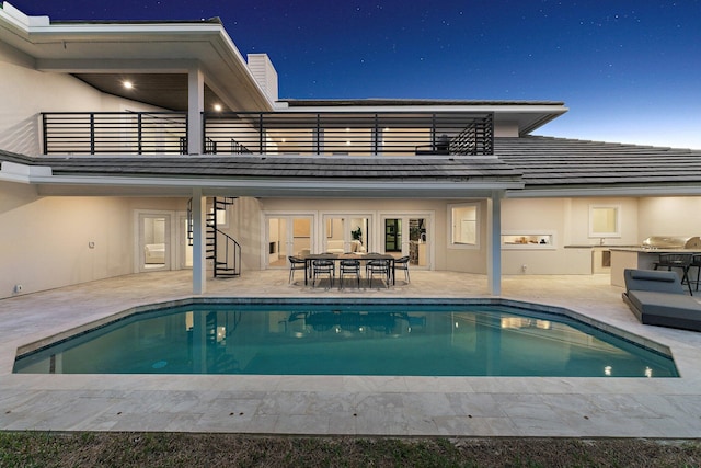 view of swimming pool featuring exterior kitchen and a patio area