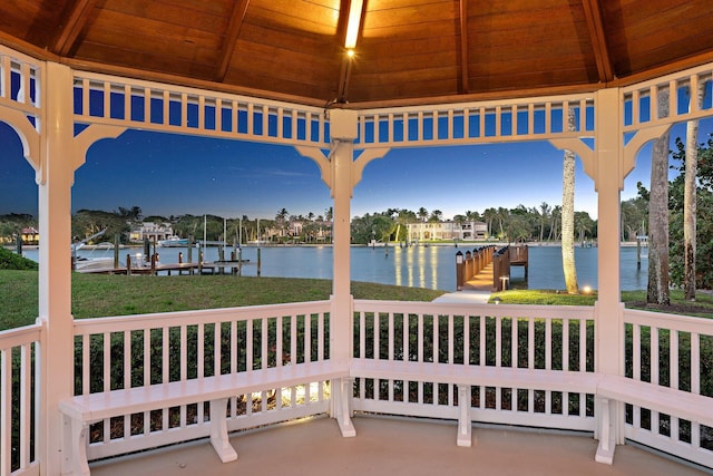 view of patio featuring a boat dock, a gazebo, and a water view