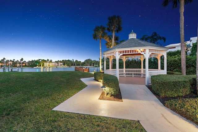 surrounding community with a water view, a gazebo, and a lawn