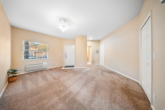 unfurnished living room featuring carpet flooring and a wall unit AC