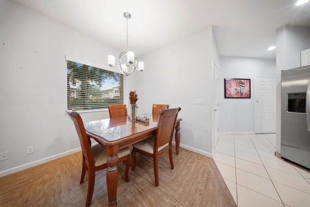 dining room with light hardwood / wood-style flooring and an inviting chandelier