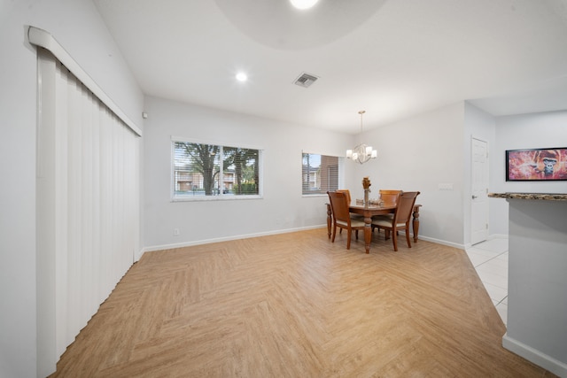 dining space featuring an inviting chandelier and light parquet flooring