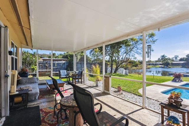 sunroom / solarium featuring a water view