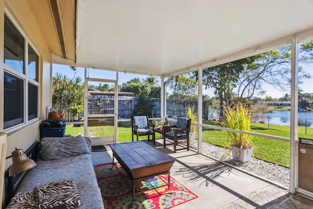 sunroom featuring a water view