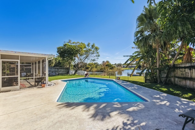 view of pool with a sunroom, a water view, a yard, and a patio