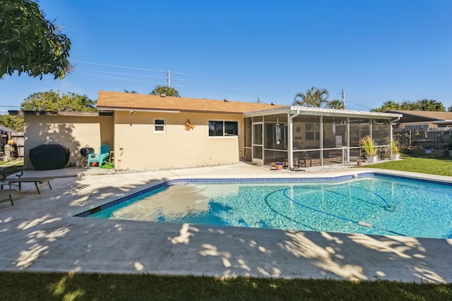 view of swimming pool with a patio area and a sunroom