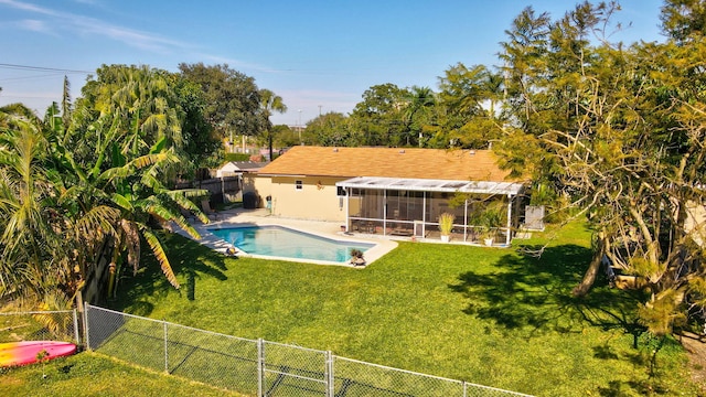 view of swimming pool with a lawn and a sunroom