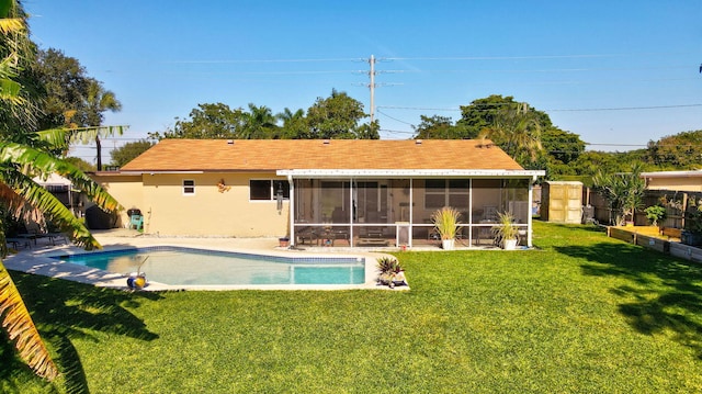 back of house featuring a sunroom, a fenced in pool, and a lawn