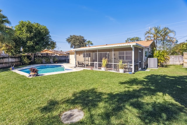 exterior space featuring a fenced in pool, a sunroom, and a yard