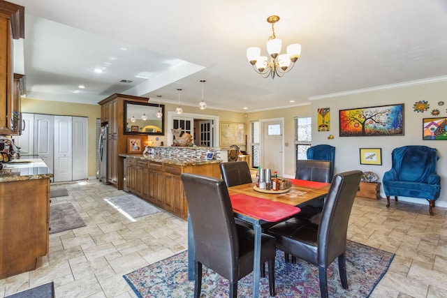 dining space with crown molding and an inviting chandelier