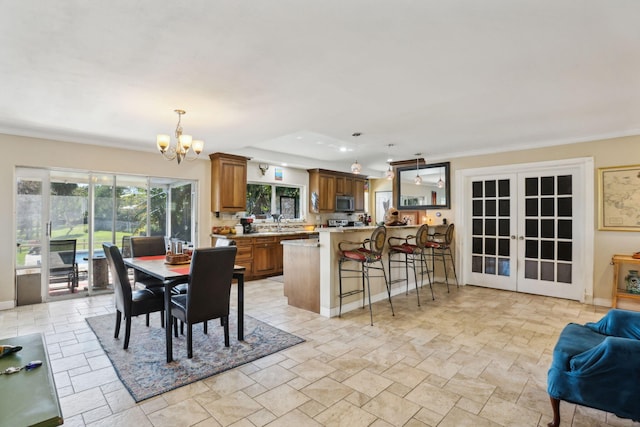 dining space with a chandelier, french doors, and sink